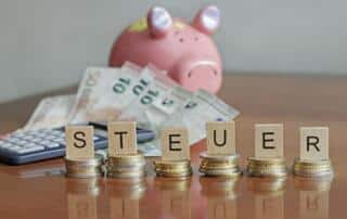 Letters spelling "steuer" (german for taxes) on stacks of coins